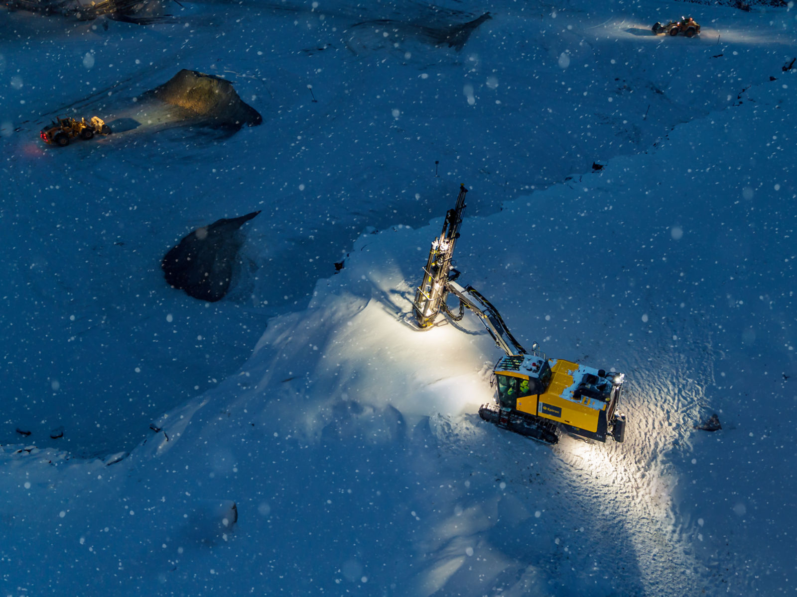 Aerial shot of a SmartROC T40 drilling on a dark and snowy night in Sweden. 