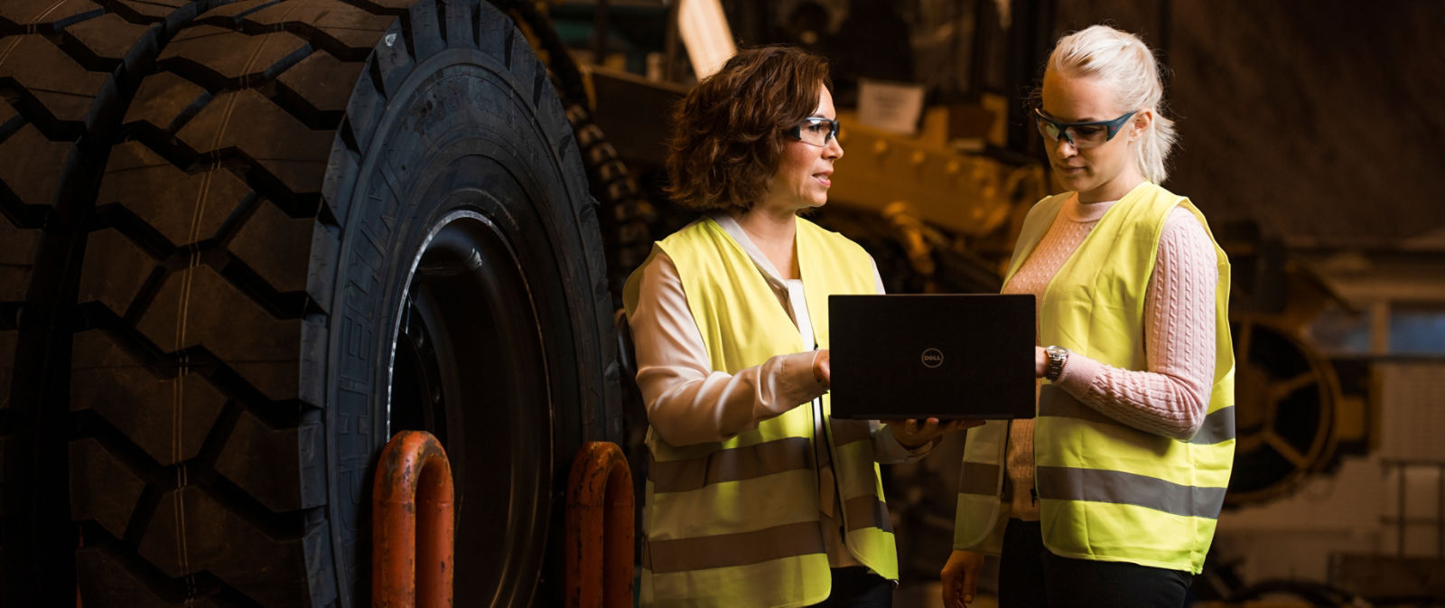 Two female colleagues looking at laptop in production environment, Örebro 